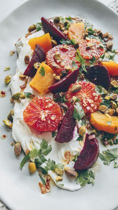 a white plate topped with fruit and nuts