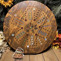 a wooden clock sitting on top of a table next to flowers