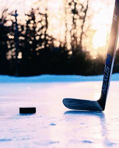 an ice hockey stick laying on top of the ice next to a small piece of puck