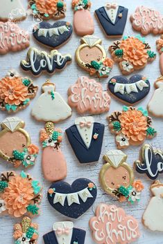 wedding cookies are arranged on a table with flowers and groom's names in the middle