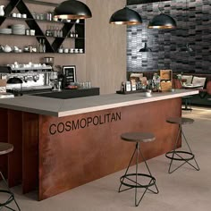 a counter with three stools in front of it that says cosmopolian