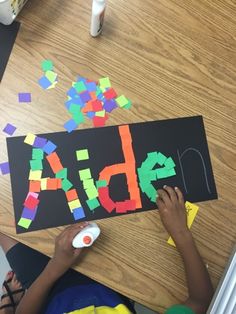 a child is making letters out of construction paper