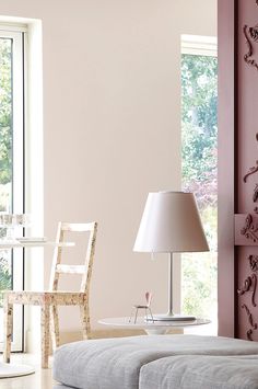 a living room with pink walls and white furniture