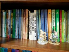 a book shelf filled with lots of books and figurines on top of it