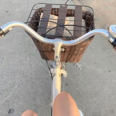 a person riding a bike with a basket on the front wheel and handlebars