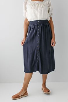 Start your day in style with the 'Greta' Skirt! This midi length, linen-blend skirt is light and airy for spring and summer and features button-down detailing for a fun touch. Pair the 'Greta' with all your favorite tops for Sunday morning or a day at the farmer's market! 30% Linen 70% Rayon Hand Wash Cold Hang to Dry Low Iron if Needed Do Not Dry Clean Fully Lined Model in Ochre Height 5'5" | Wearing Size Small Wearing 'Shalom' Geometric Print Top in Tan & 'Greta' Linen Blend Midi Skirt in Ochre Model in Ochre & Dark Blue Height 5'8" | Wearing Size 1X Wearing 'Sybil' Embroidered Square Neck Top & 'Greta' Linen Blend Midi Skirt in Ochre Wearing 'Shalom' Geometric Print Top in Tan & 'Greta' Linen Blend Midi Skirt in Dark Blue Model in Dark Blue & Black Height 5'9" | Wearing Size Small Weari Knee-length Summer Bottoms With Buttons, Rayon Midi Maxi Skirt For Day Out, Casual Maxi Skirt With Button Closure For Summer, Summer Linen Midi-length Bottoms, Spring Relaxed Skirt With Buttons, Summer Midi Skirt In Rayon, Linen Flowy Skirt For Vacation, Spring Long Skirt With Buttons, Summer Midi-length Rayon Skirt