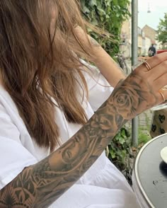 a woman sitting at an outdoor table eating food