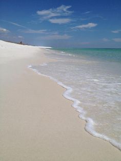 an empty beach with white sand and clear water