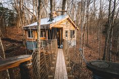 a small wooden cabin in the woods with a roped off walkway leading up to it