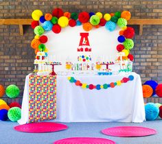 a birthday party with colorful decorations and paper plates on the floor next to a table