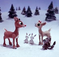 several toy animals are standing in the snow