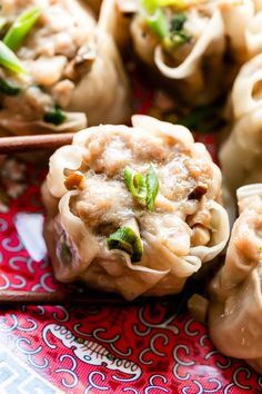 some dumplings are sitting on a plate with chopsticks