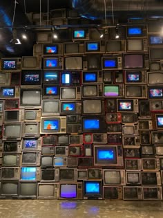 there are many tvs stacked up on the wall