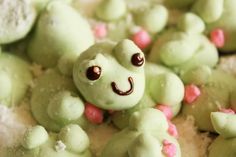 a close up of some green cookies with pink sprinkles on them and a smiling frog in the middle