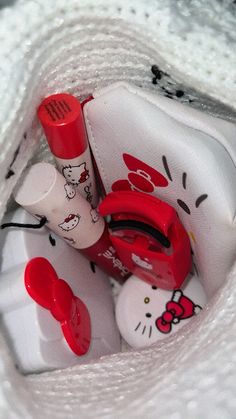 the hello kitty bag is packed with all kinds of items in it, including lipstick and toothbrushes