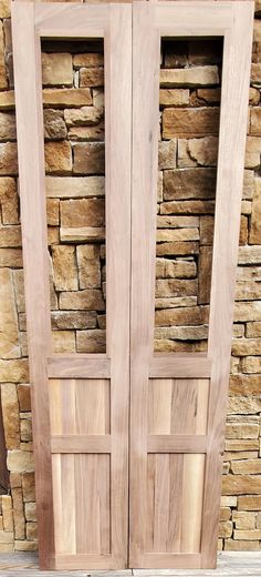 two wooden doors sitting next to each other on top of a stone wall and floor