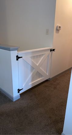 an empty room with a white door and some black hardware on the side of it