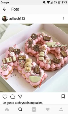 a box filled with lots of pink frosted donuts