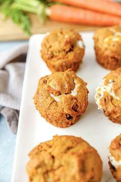 carrot muffins with cream cheese on top and carrot sticks in the back ground