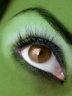 the eye of a woman with green makeup