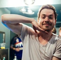 a man standing in front of a mirror with his hand on his head