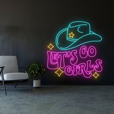 there is a neon sign that says let's go girls with a hat on it