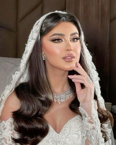 a woman in a wedding dress posing for the camera with her finger on her lips