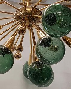 a chandelier with five green glass balls hanging from it's center point