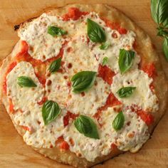 a pizza with cheese, sauce and basil leaves