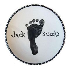 a hand and foot imprint on a white cake with black lettering that says jack 8 weeks