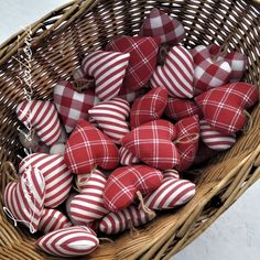 a basket filled with red and white striped heart shaped ornaments in it's center