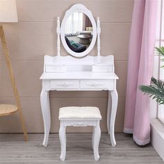 a white dressing table with a mirror and stool