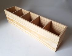 a wooden box that has compartments in it on a white surface with a gray background