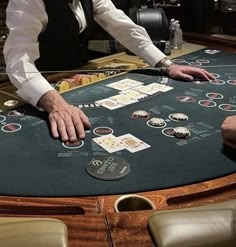 two men playing blackjack at a casino table with chips and cards on the table