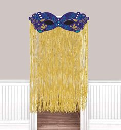 a blue and yellow masquerade mask hanging from the side of a white door