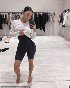 a woman taking a selfie in a clothing store