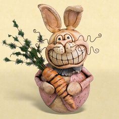 a ceramic sculpture of a rabbit holding a carrot