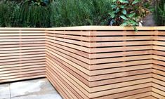 a large wooden wall in front of some plants