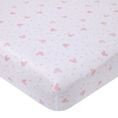 a pink and white baby crib sheet with mickey mouse print on it's side