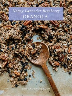 a wooden spoon filled with granola on top of a table