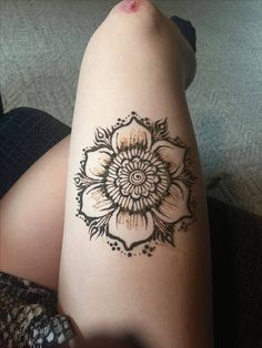 a woman's leg with a tattoo on it that has a flower in the middle