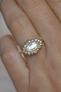 a woman's hand with a diamond ring on top of her finger and an engagement band