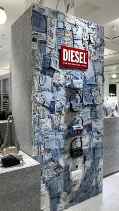 a display in a clothing store with blue jeans on the wall and handbags hanging from hooks