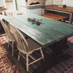 a wooden table with white chairs around it in a room filled with other furniture and decor