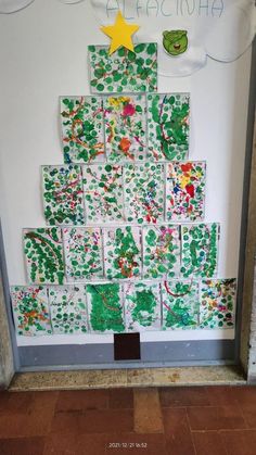 a child's christmas tree made out of handprinted paper on the wall