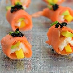 several sushi rolls with vegetables and black cavias on the top one is cut in half