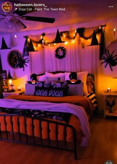 a bedroom decorated for halloween with purple lights and decorations on the wall above the bed