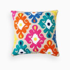 a multicolored decorative pillow on a white background with an orange, blue, yellow and pink flower pattern