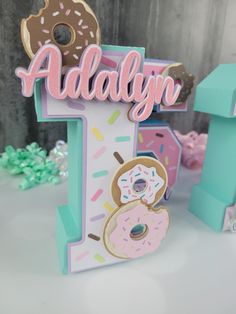 a handmade wooden sign with doughnuts and sprinkles