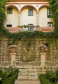 an old building with ivy growing on it's walls and steps leading up to the entrance